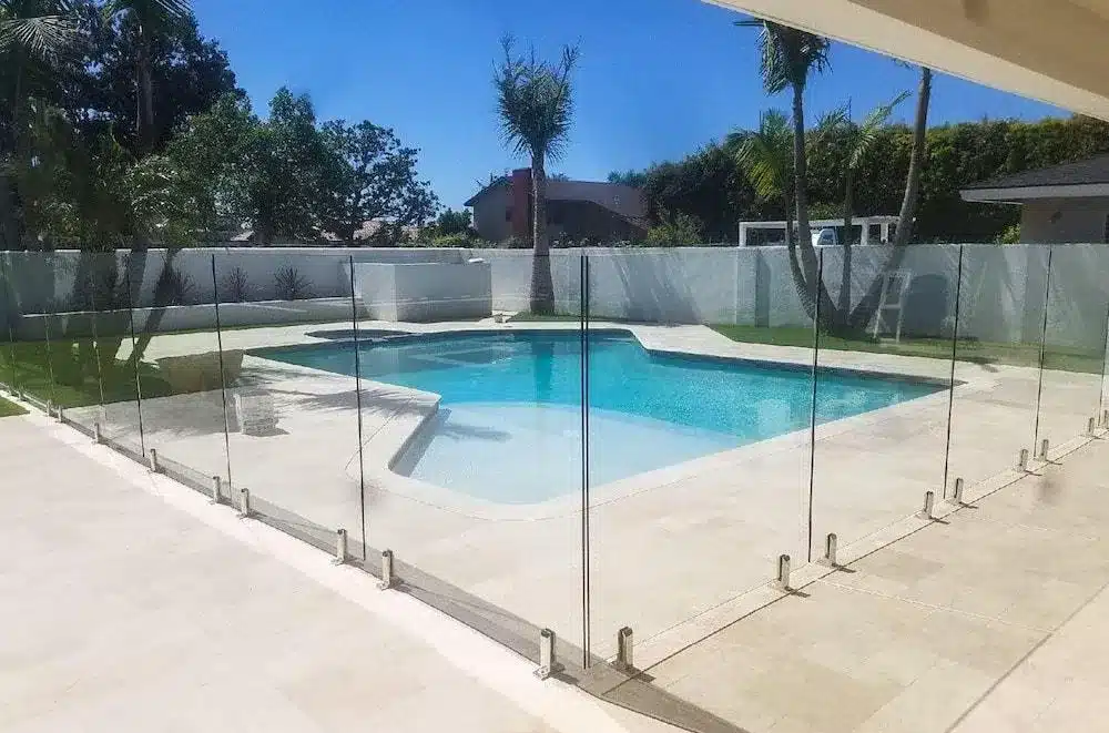 Frameless glass pool fencing around an L-shaped pool